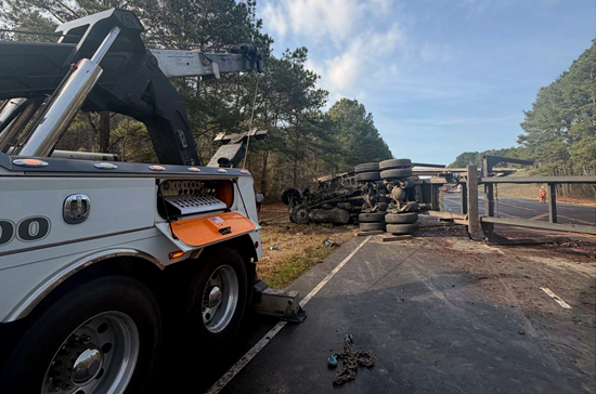 Overturned tractor trailer being recovered by heavy duty tow truck near I-40 in Warsaw North Carolina